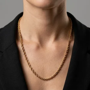 Cadena lazo en tono oro puesta en el cuello de una mujer elegante, con estilo de joyería premium y fondo sobrio.