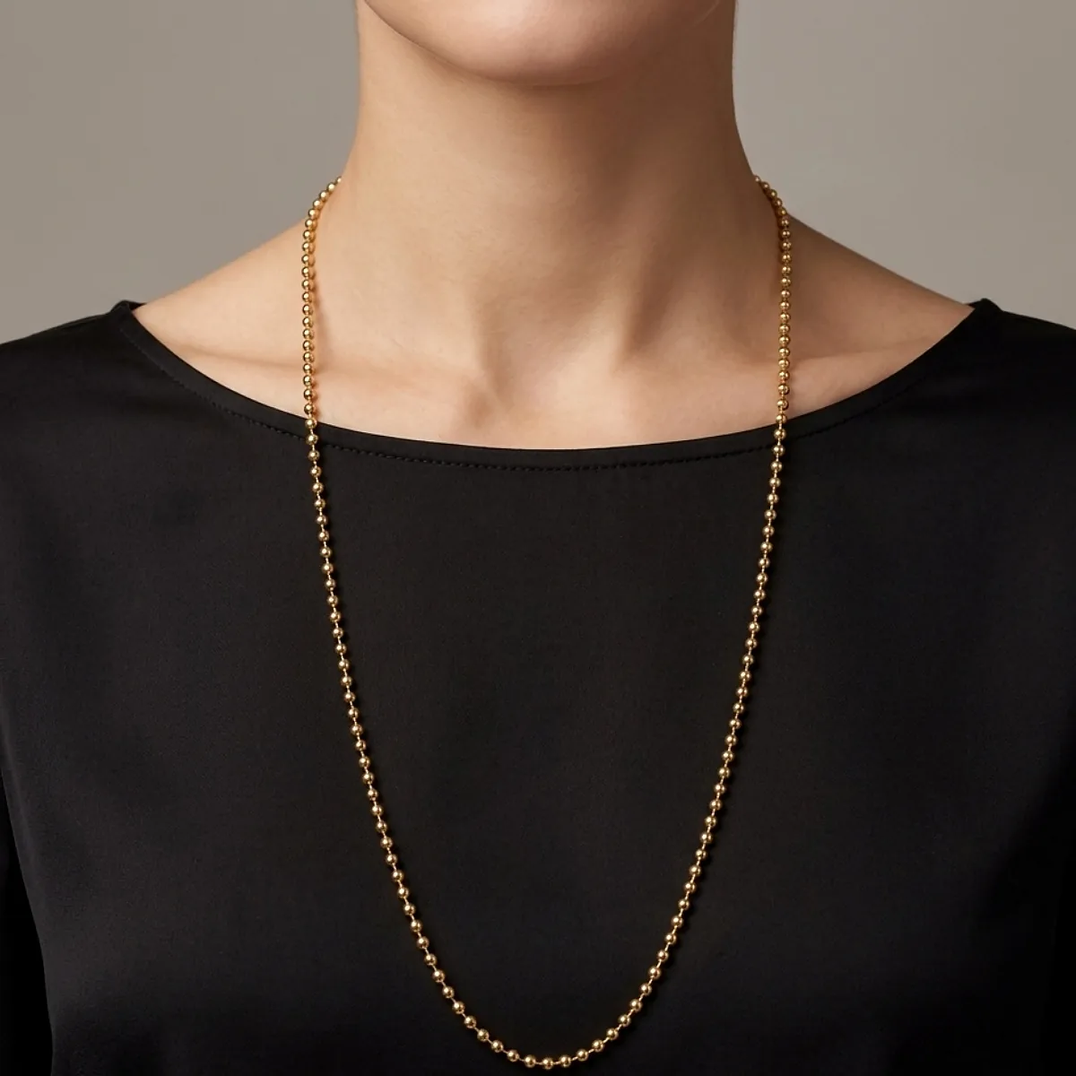 Cadena militar en tono oro puesta en el cuello de una mujer elegante, joya de Luxor SM Joyería en Santa Marta.