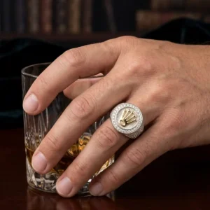 Anillo masculino bicolor con corona central y circones sobre mano de hombre, joya de lujo de Luxor SM Joyería en Santa Marta.