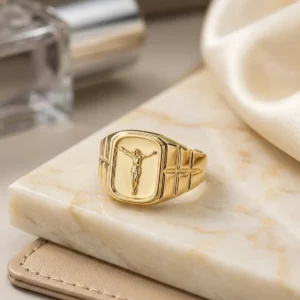 Anillo de Jesucristo dorado para mujer sobre mano femenina elegante, joya religiosa de Luxor SM Joyería en Santa Marta.