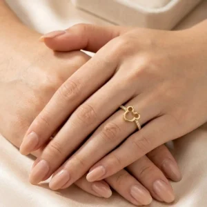 Anillo dorado con silueta tipo trébol sobre mano femenina elegante, joya fina de Luxor SM Joyería en Santa Marta.