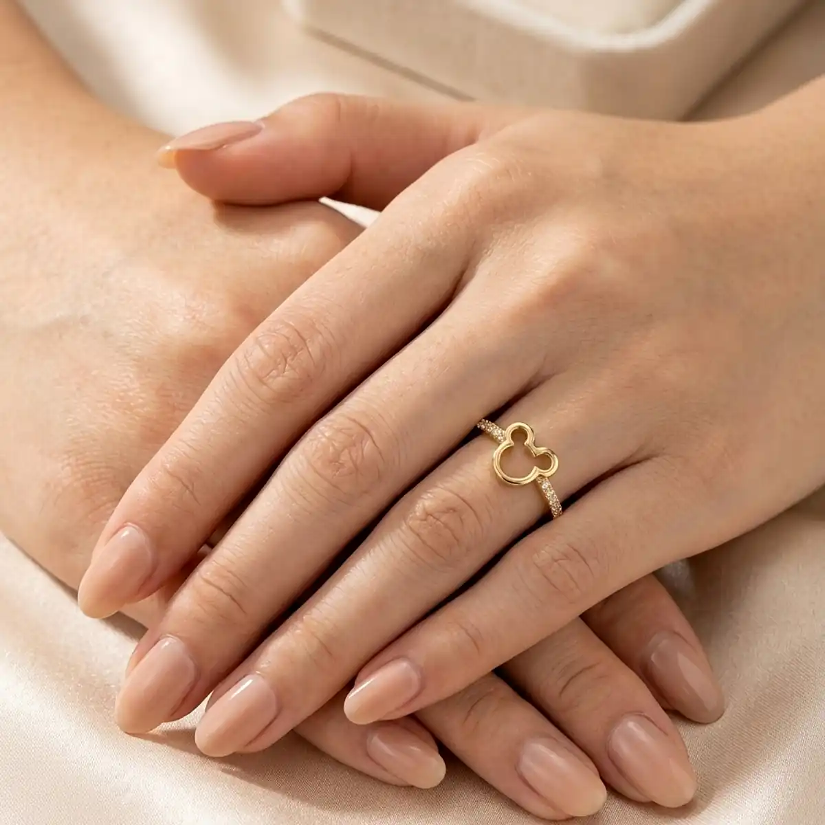 Anillo dorado con silueta tipo trébol sobre mano femenina elegante, joya fina de Luxor SM Joyería en Santa Marta.